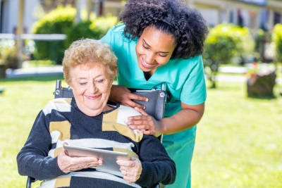 caregiver accompanying her senior patient on a wheelchair